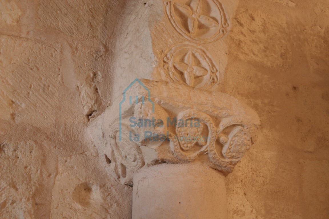 Detalle de una portada remontada en el interior decorada con tetrapétalasde botón central inscritas en clípeos, e imposta decorada con tallos ondulados con pámpanos