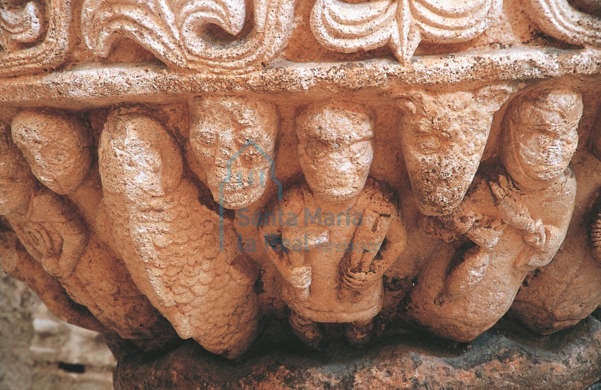 Detalle de la pila bautismal, con figuras de San Pedro, un gran pez, un herrero y una mujer hilando