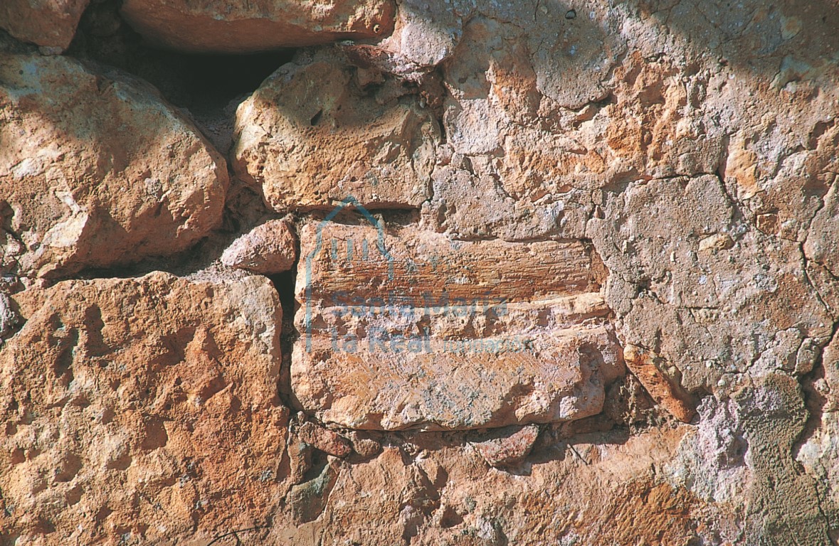Dovela románica reutilizada en el muro sur