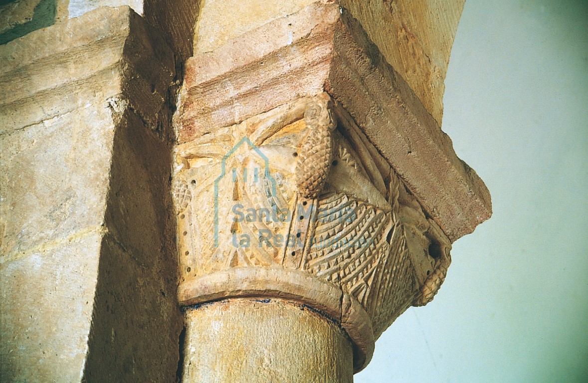 Capitel del evangelio del arco triunfal decorado con volutas, piñas y hojas geometrizadas