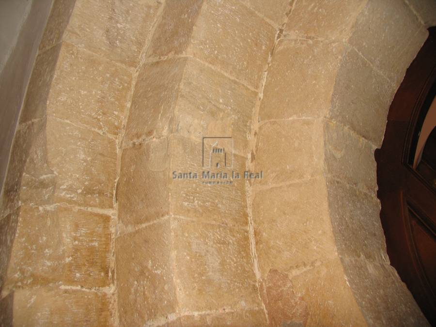 Detalle de las arquivoltas de la portada románica situada en el último tramo del muro del evangelio