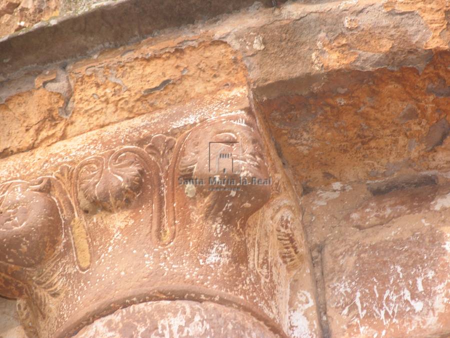 Capitel de una semicolumna en el exterior del ábside. Cara y flores