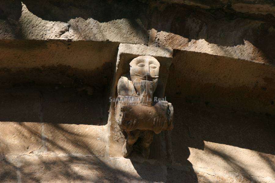 Canecillo del ábside. Hombre bebiendo de un barril