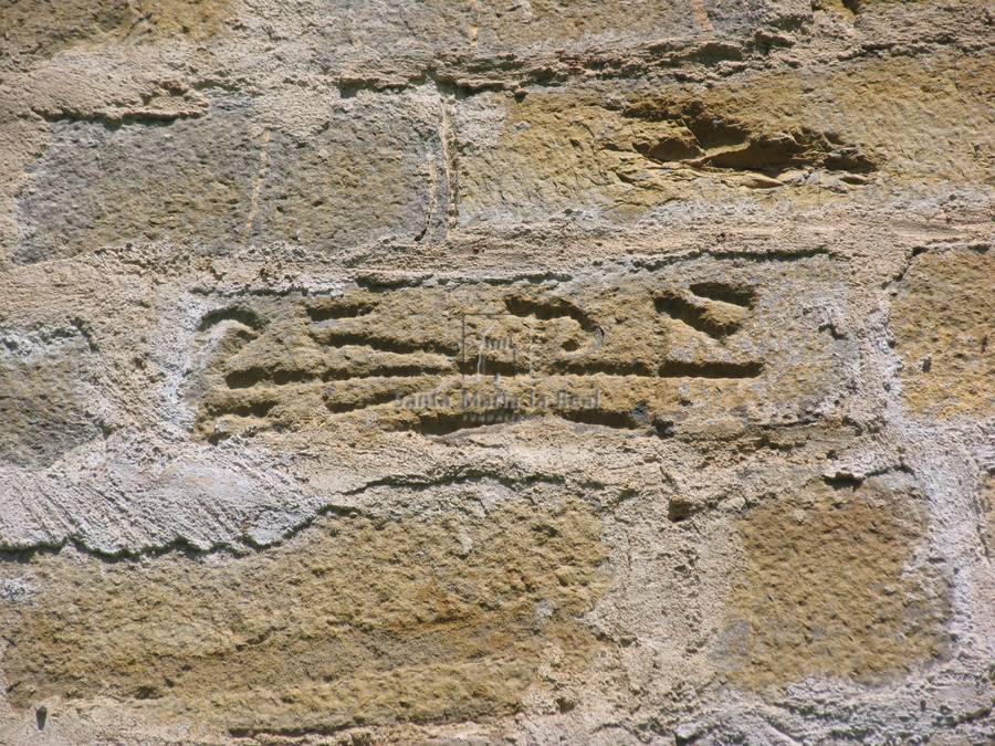 Sillar grabado con una espiga horizontal en el muro de la epístola