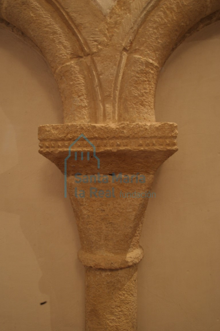 Detalle del capitel de la arquería ciega del presbiterio con cimacio sencillo decorado con una hilera de pequeñas puntas de clavo