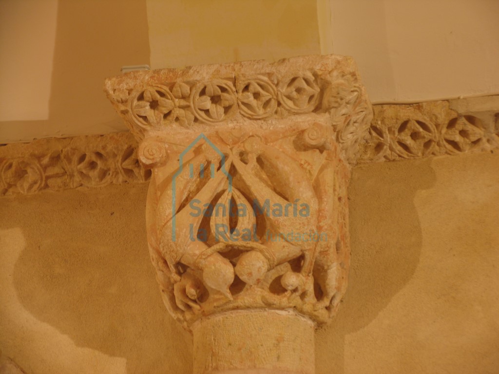 Capitel de uno de los arcos fajones de la nave central decorado con estilizados grifos que contraponen sus cuerpos mientras juntan sus picos y los extremos de sus colas y alas