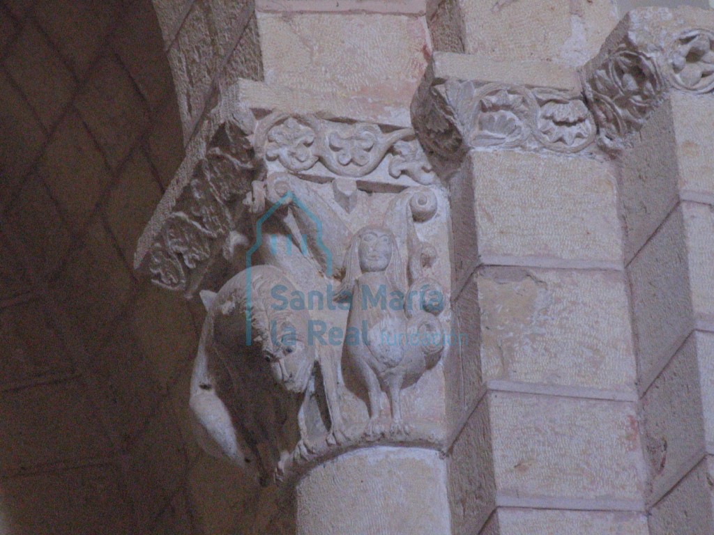 Capitel del arco triunfal decorado con un león en la cara mayor y una arpía en la menor