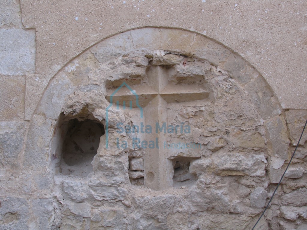 Arcosolio de medio punto con restos de pinturas postmedievales, con una de las cruces del calvario que rodearía la iglesia
