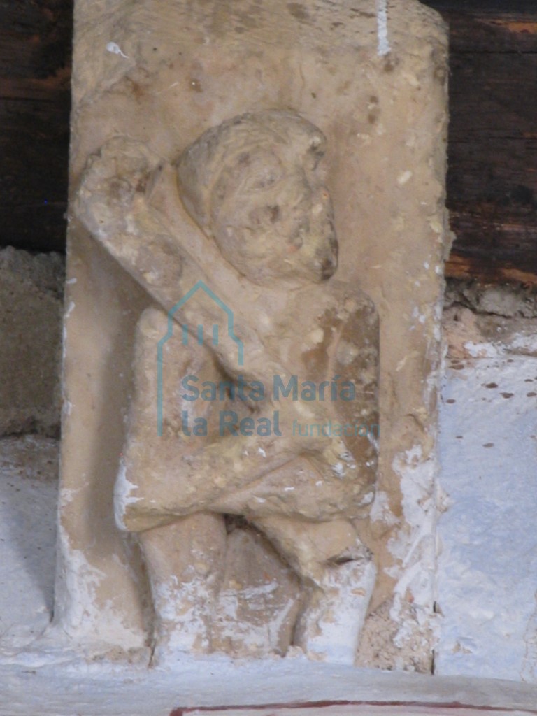 Canecillo figura humana con un garrote en la nave sur