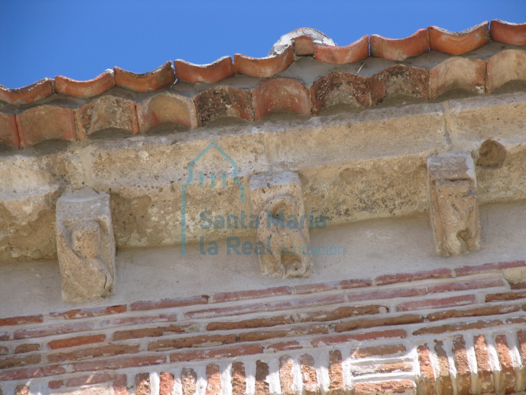 Canecillos en la cornisa de la fachada sur. hombre alado, basilisco y asno tocando la lira