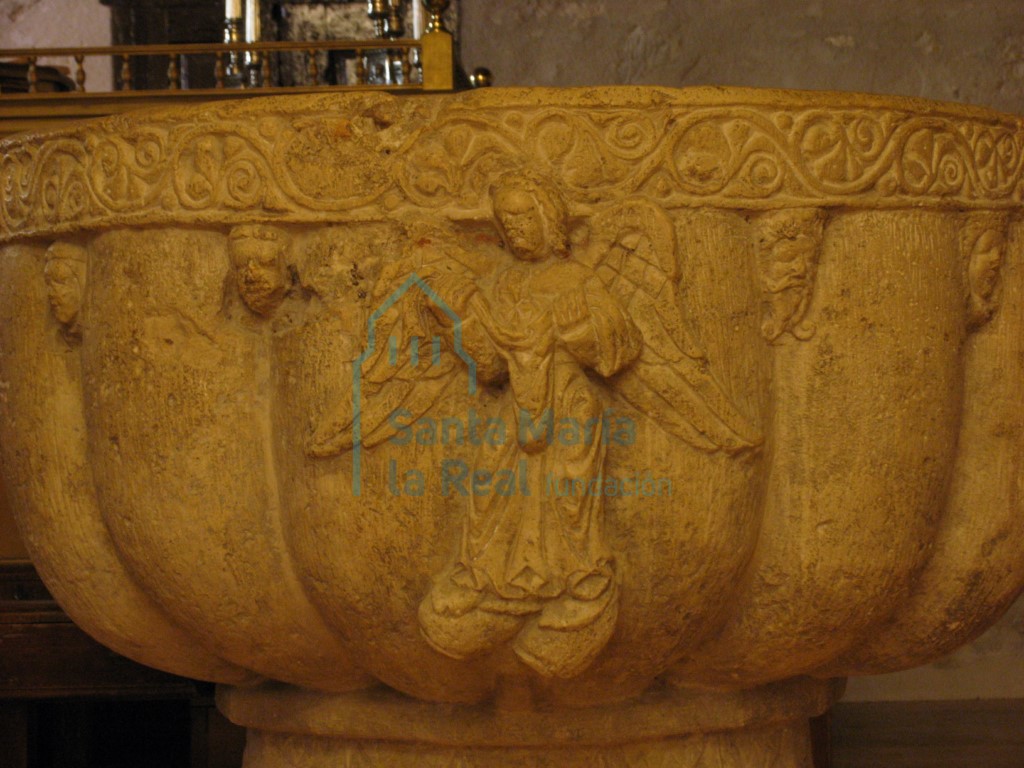 Relieve de un ángel en la copa de la pila bautismal