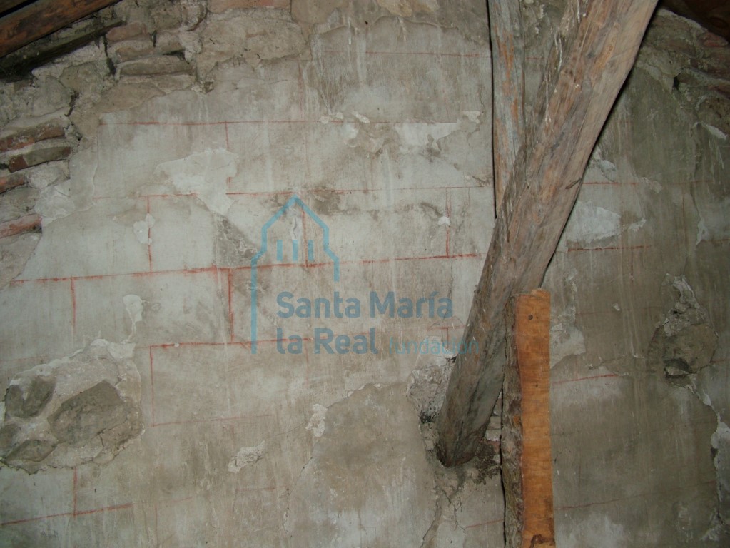 Detalle de restos de pintura simulando despiece de sillares mediante líneas rojizas