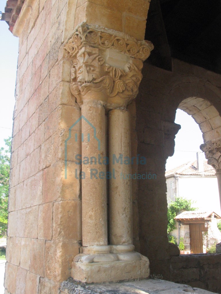 Columna pareada con capitel con dos mascarones que asemejan un felino mostrando las fauces, en el lado meridional del pórtico