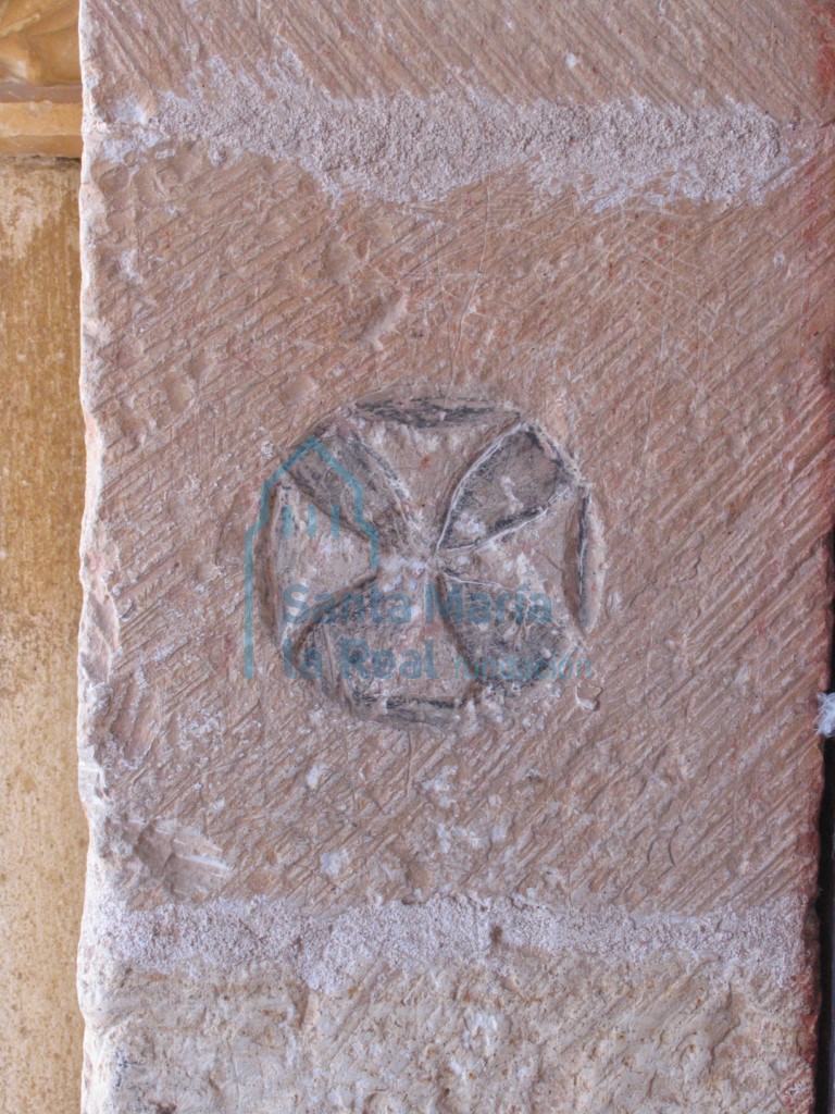 Cruz en relieve o flor de cuatro pétalos, en la jamba de la portada meridional