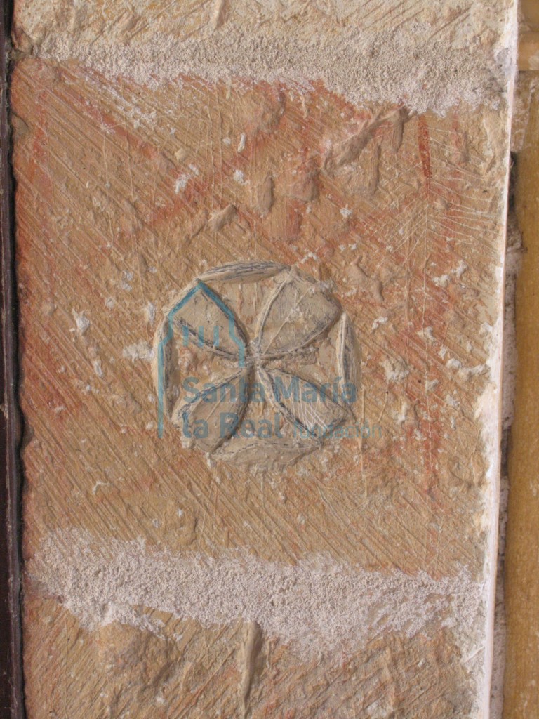 Cruz en relieve o flor de cuatro pétalos, en la jamba de la portada meridional