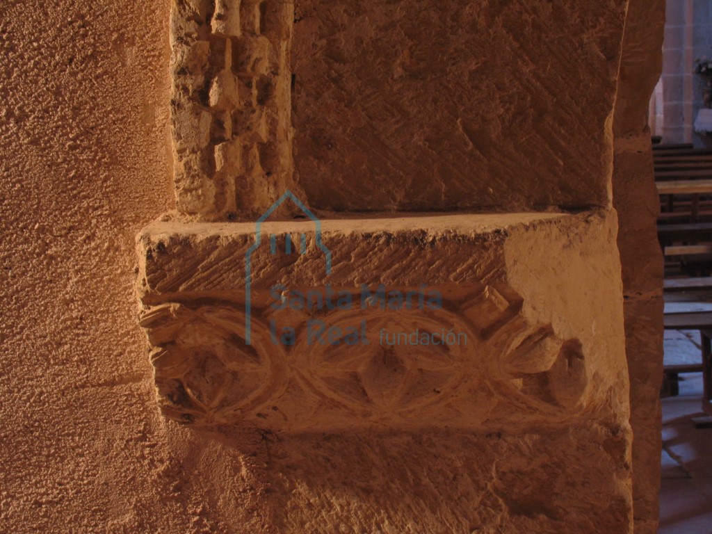 Imposta que representa flores de cuatro pétalos inscritas dentro de círculos, en el el arco ubicado a los pies de la nave