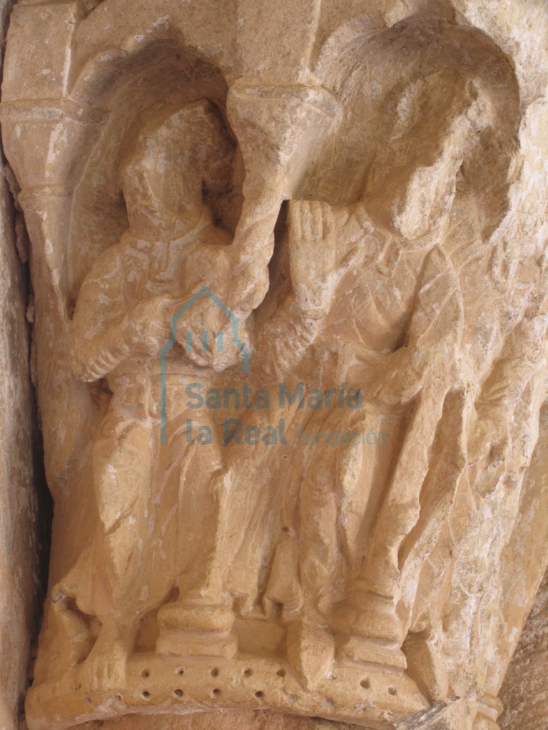 Capitel que representa figuras humanas en el interior de arquerías