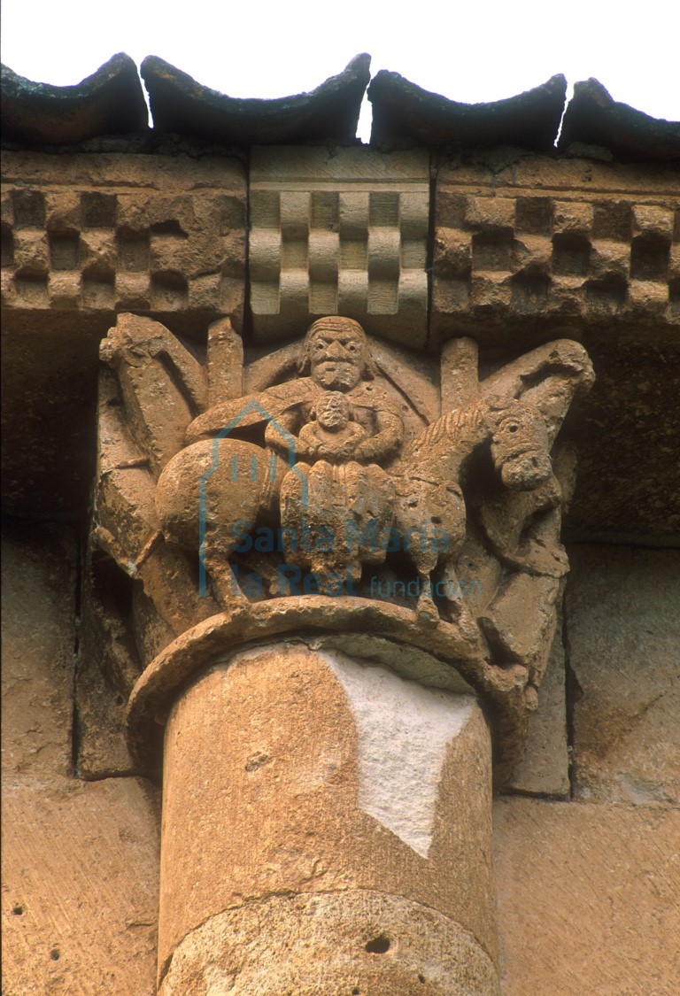 Capitel del ábside. Huida a Egipto, con una representación arquitectónica en la cara sur, la Virgen con el Niño en su regazo sobre la montura  en el frente y en la otra cara a San José tirando de sus riendas