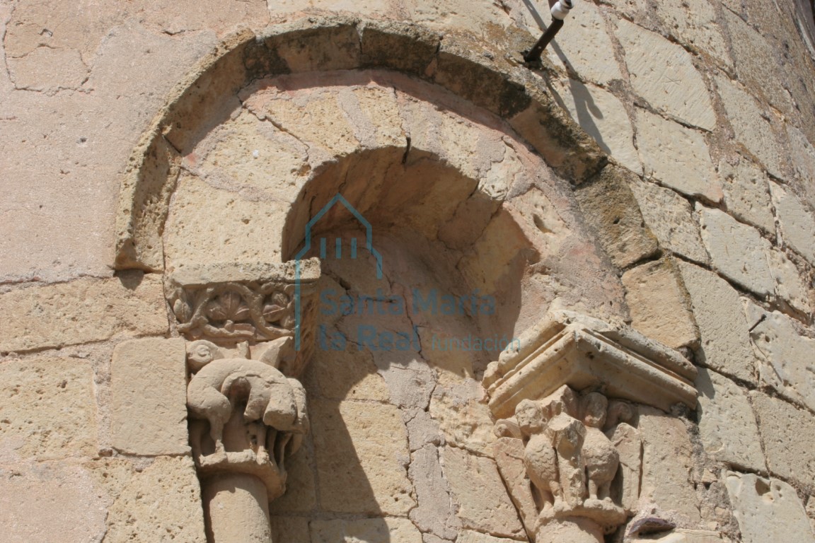 Vista del arco de medio punto y los capiteles de la aspillera del ábside