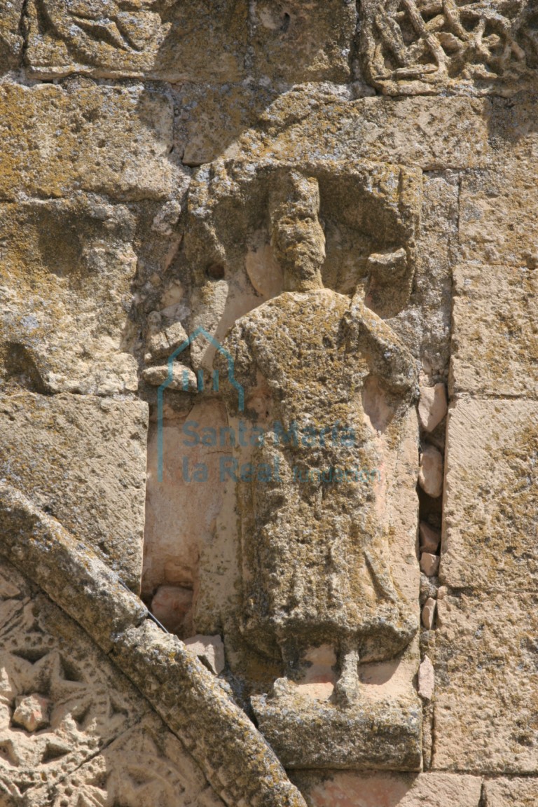 Detalle de la enjuta derecha, relieve de un eclésiastico vestido con ropas talares y sosteniendo un libro en su extendida diestra