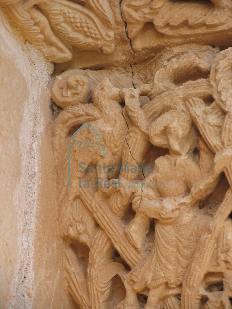 Detalle del capitel derecho con dos figuras humanas luchando con dos animales fantásticos entre la vegetación, en la portada