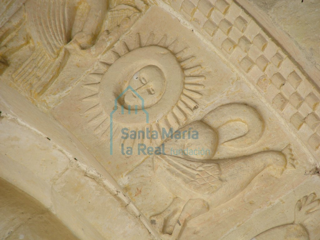 Representación del sol y de un ave en arquivolta exterior de la portada meridional