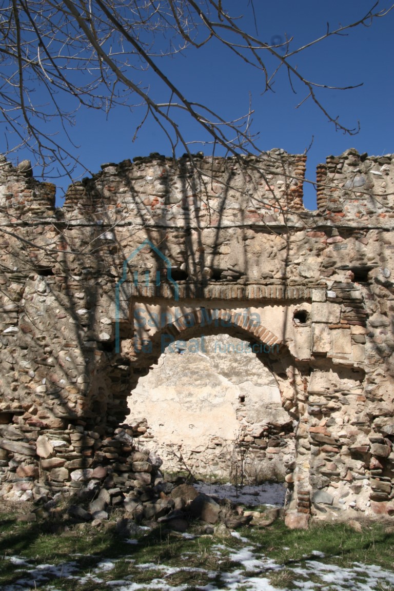 Portada meridional de arco apuntado de ladrillo con las ejutas enfoscadas y enmarcado por un alfíz