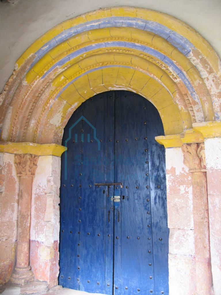 Portada románica de sillería formada por un arco de medio punto con las dovelas lisas sin decoración  y dos arquivoltas.