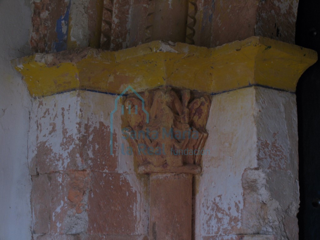 Detalle de la imposta y el capitel de temática mitológica en el que se prepresenta un fondo vegetal con un deteriorada sirena de doble cola sin cabeza.