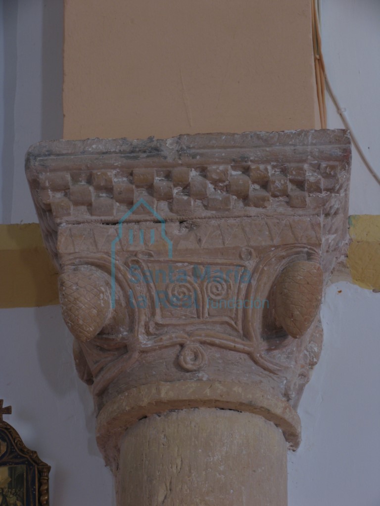 Capitel del arco triunfal en el lado del evangelio, decorado con frutos en forma de piña en las esquinas que penden de un pequeño tallo y en la parte central un motivo geométrico