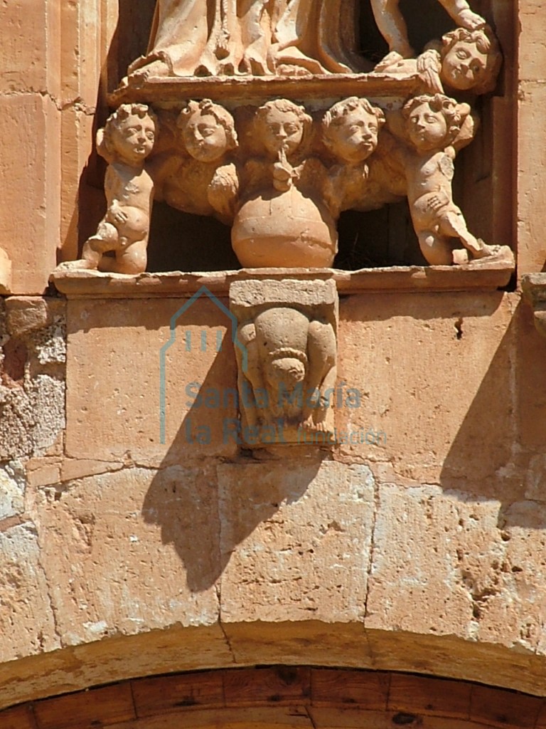 Detalle de la la hornacina de la fachada en la que se observa un canecillo románico reaprovechado. Representa una figura mostruosa encandenada