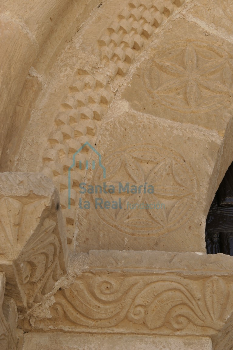 Detalle del cimacio y la decoraciónde las dovelas de flores hexapétalas inscritas en una línea fila de perlitas