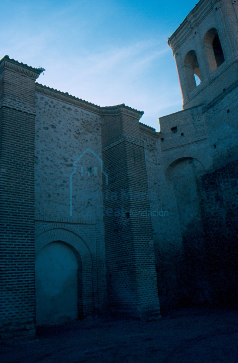 Portada gótica cegada en el muro norte, torre y arco de descarga que una la torre al muro norte