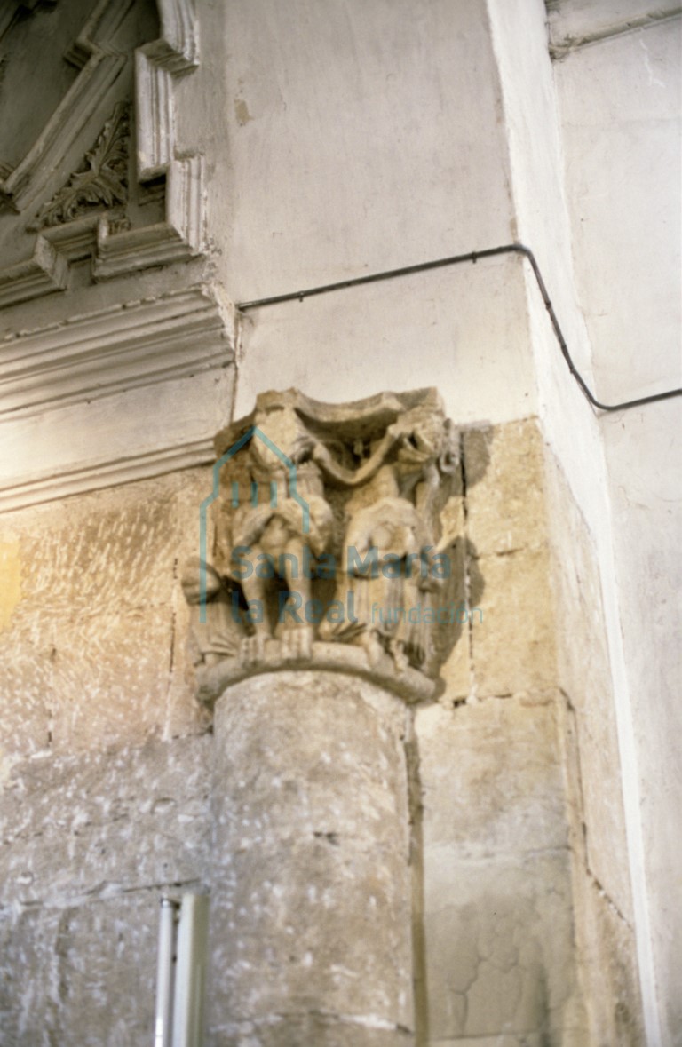 Capitel meridional del arco toral del absidiolo norte. Figura demoníaca en actitud devoradora rodeada de figuras monstruosas y flanqueada por figuras femeninas sedentes