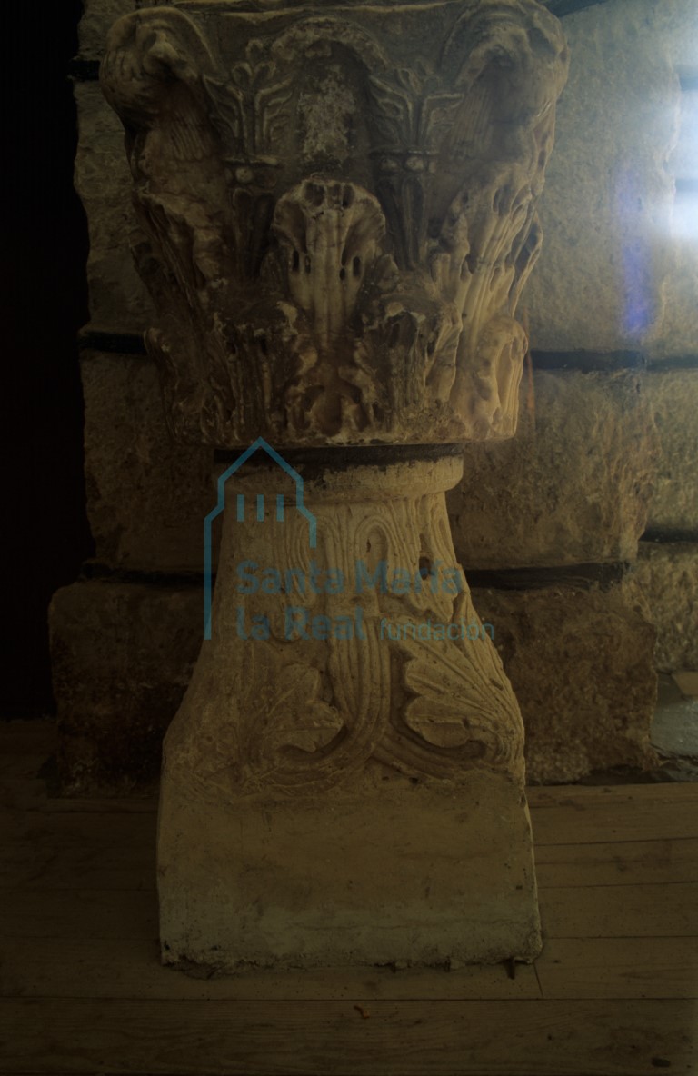 Capitel románico como base de la pila aguabenditera: una de sus caras es lisa, apta para el adosamiento