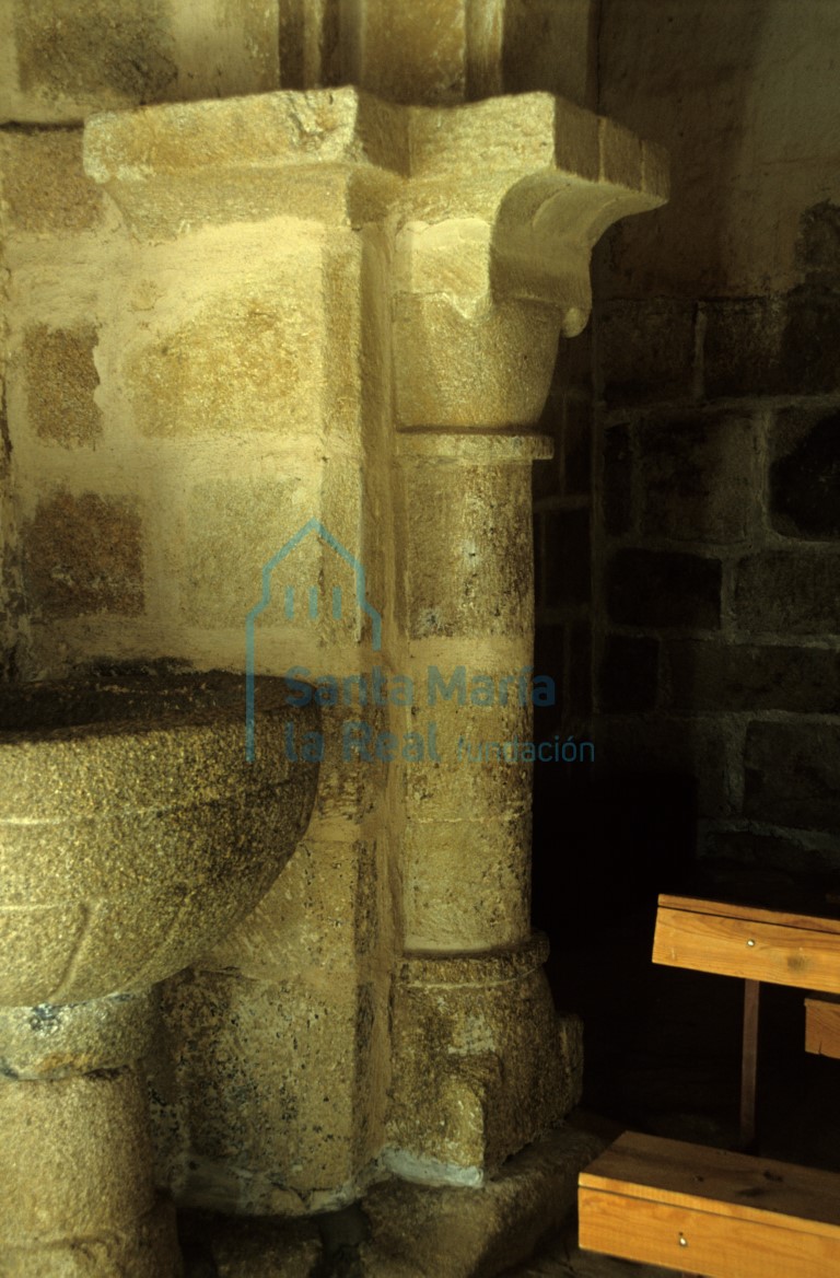 Vista de un pilar y de la pila bautismal en el interior del templo