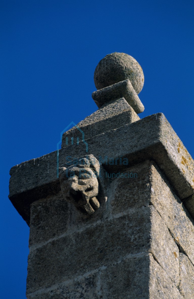 Detalle del remate barroco del hastial.Canecillo románico de cabeza monstruosa