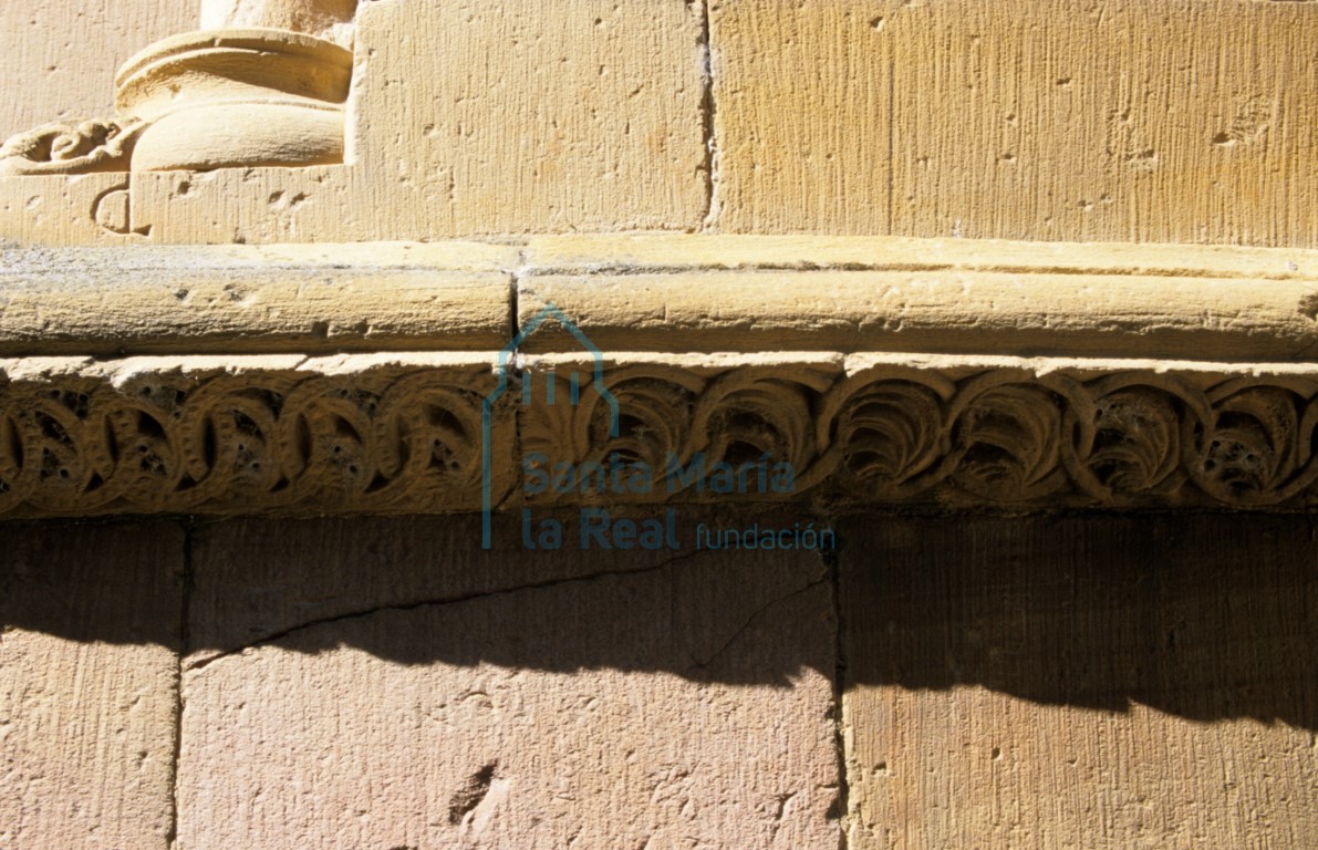 Detalle de la imposta  en el exterior de la cabecera del ábside central. Decoración de tetrapétalas en clípeos perlados, tallos ondulados con brotes y círculos perlados secantes