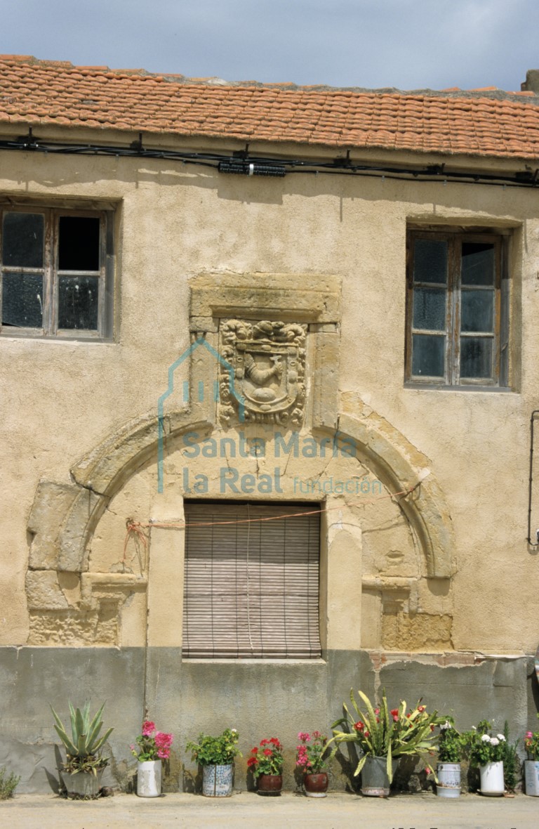 Fachada de una casa con arco y escudo nobiliario