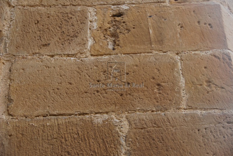Marca de cantero en el muro del claustro